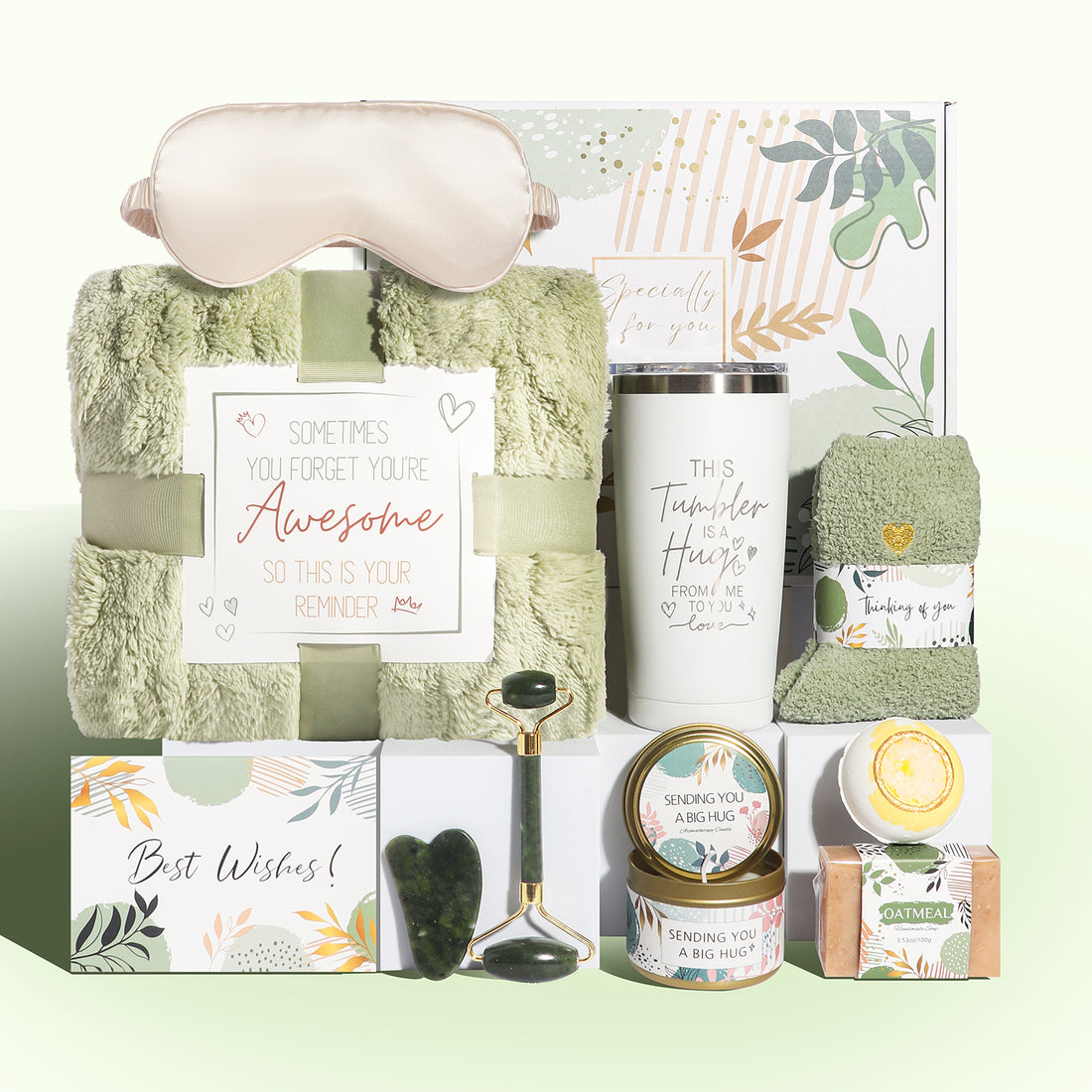 Green wellness gift box with blanket, tumbler, jade roller set, socks, candle, oatmeal soap, bath bomb and sleep mask.