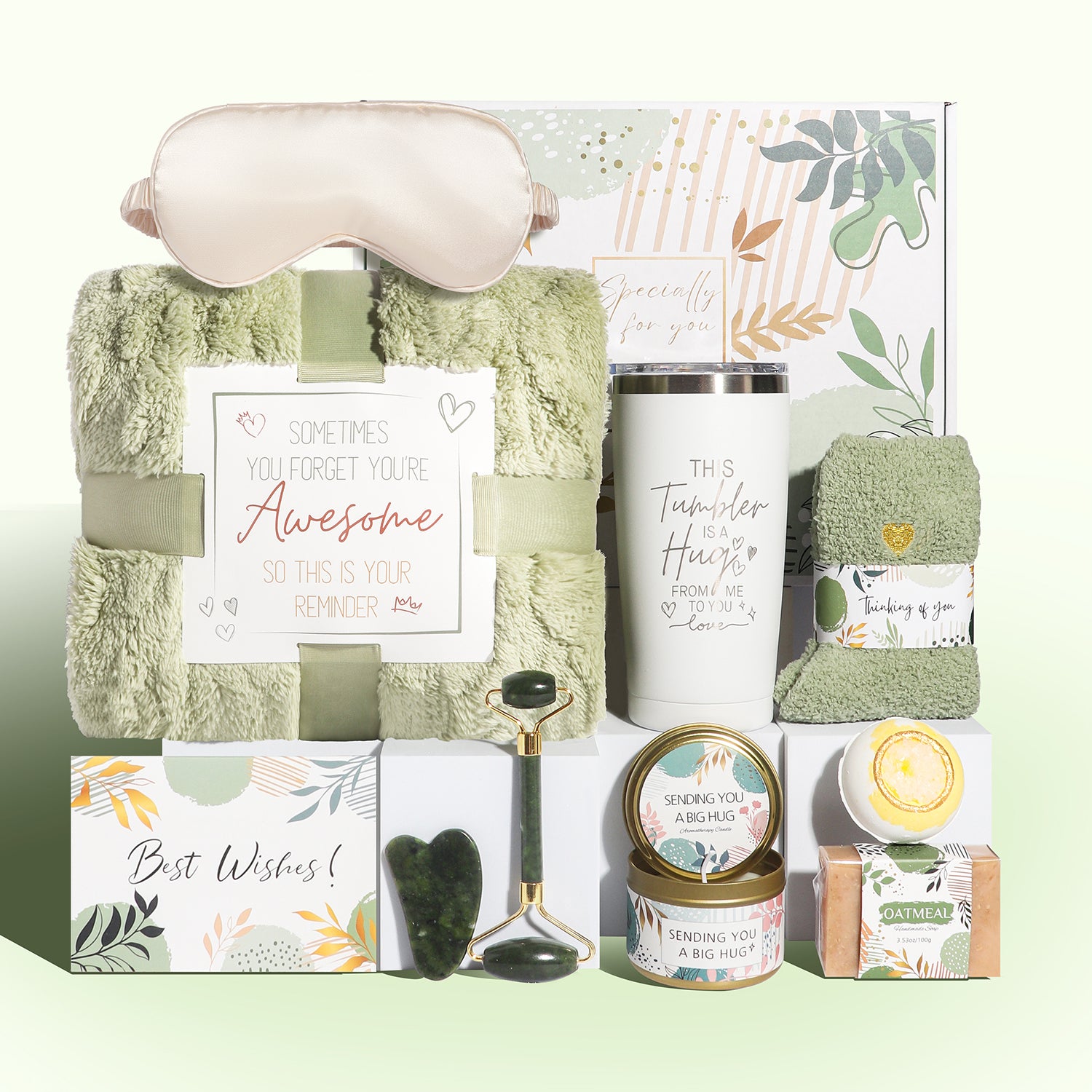 Green wellness gift box with blanket, tumbler, jade roller set, socks, candle, oatmeal soap, bath bomb and sleep mask.