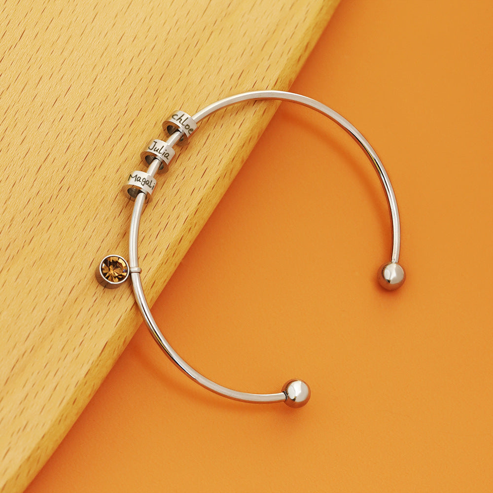 Personalised birthstone bangle with engraved name bead in gold and silver