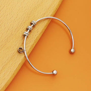 Personalised birthstone bangle with engraved name bead in gold and silver