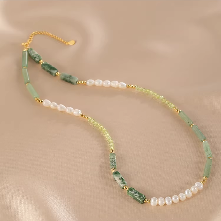 Handmade pearl and jade beaded necklace on neutral background