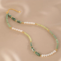 Handmade pearl and jade beaded necklace on neutral background
