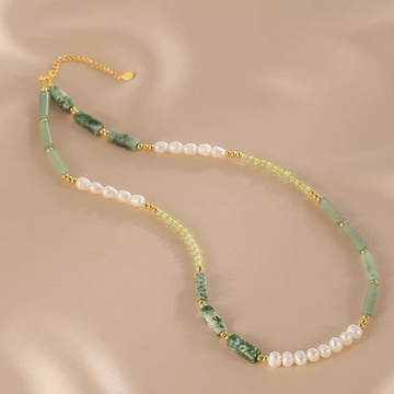 Handmade pearl and jade beaded necklace on neutral background