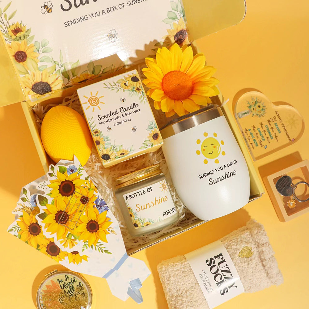 Sunshine themed gift box featuring sunflower bouquet, stainless-steel tumbler, scented candle, fuzzy socks, stress ball, inspirational acrylic plaque and makeup mirror.