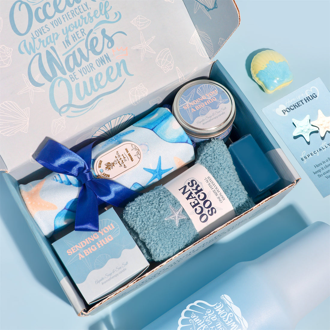 Ocean themed pamper gift box with shell tumbler, towel, fuzzy socks, candle, ocean soap, shell bath bomb and pocket hug card.
