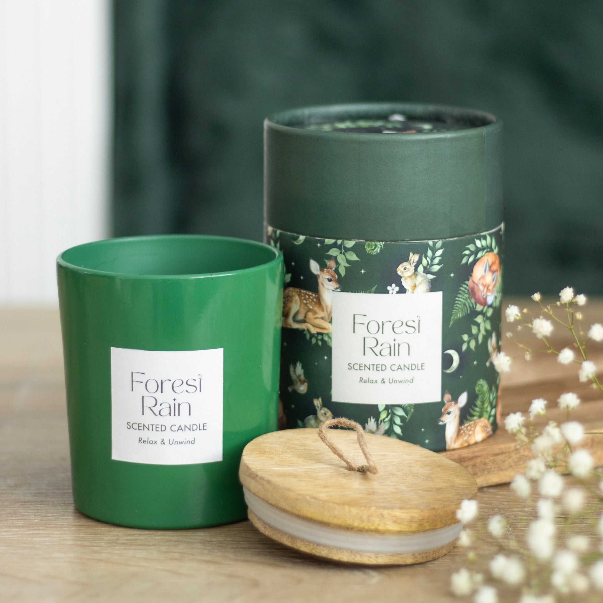 Forest Rain scented candle in green jar with wooden lid and illustrated gift box – nature-inspired home fragrance.