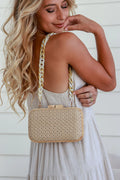 Woman holding a natural woven clutch with resin chain strap – Riviera handbag gift for her NZ
