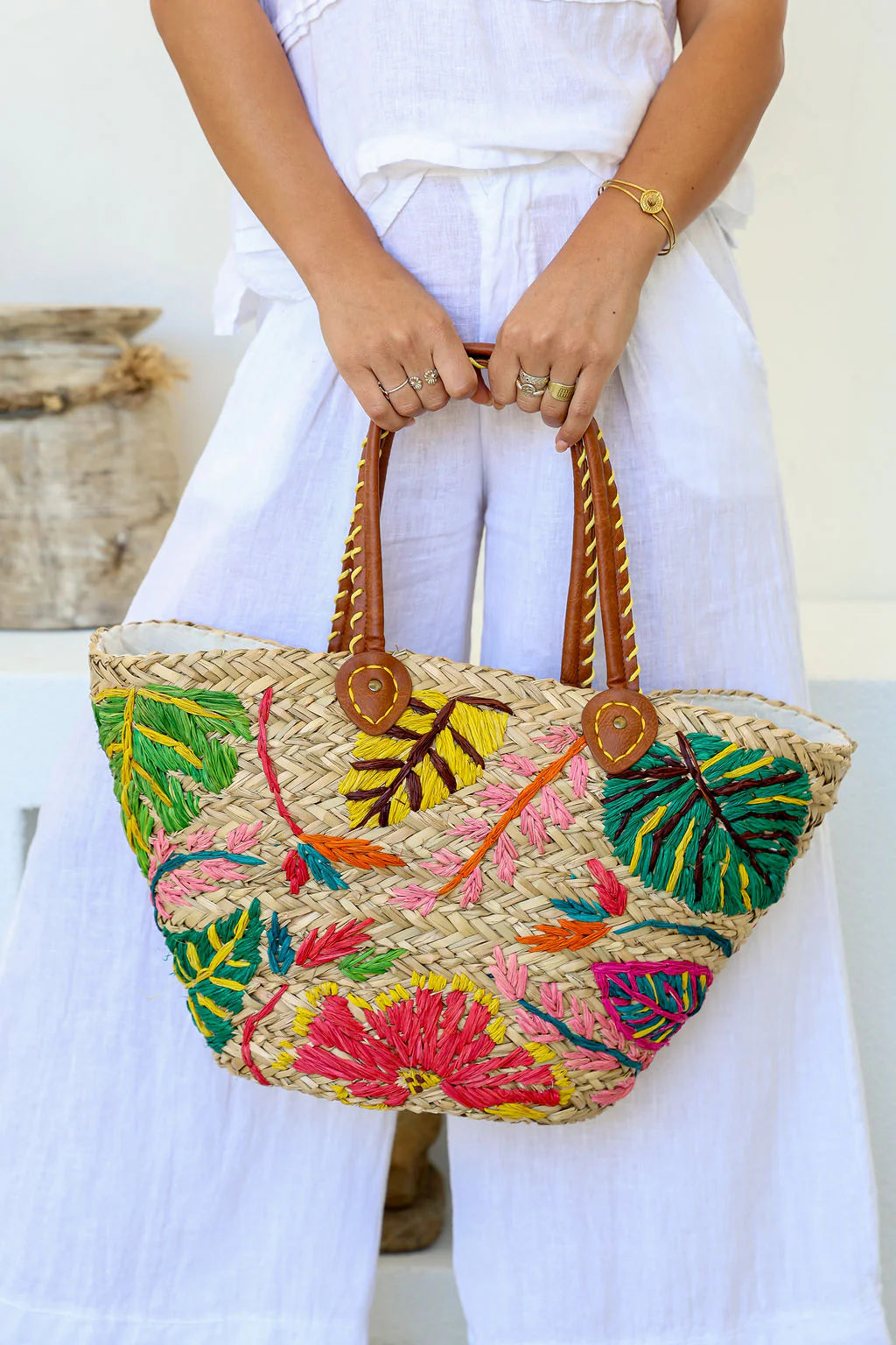Woman holding a floral tropical woven straw tote bag – handmade summer women’s handbag and beach gift for her