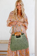 Woman holding a khaki woven tote bag with wooden handles – lightweight summer handbag and stylish gift for her