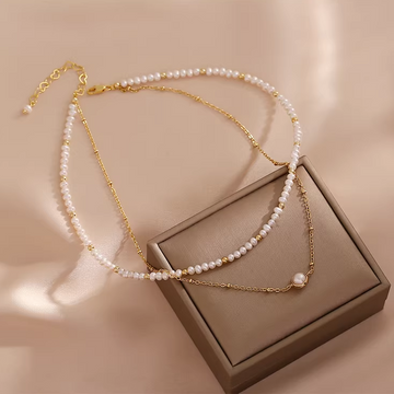 Handmade 14K gold plated freshwater pearl necklace on beige background